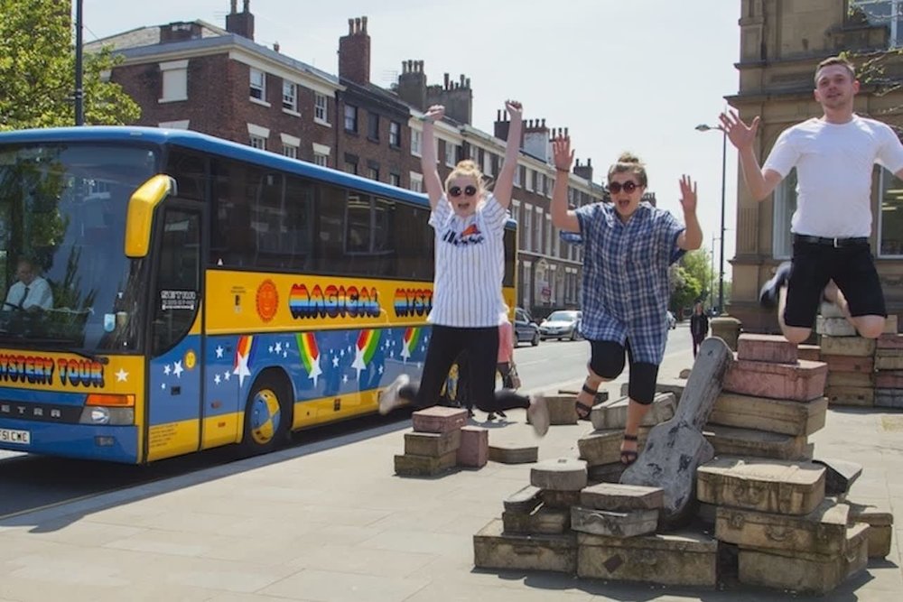 Tourists posing with the Beatles Magical Mystery bus in Liverpool