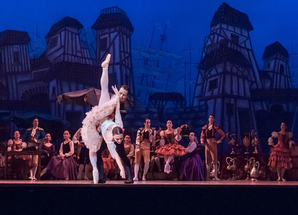 Royal Ballet dancers performing on stage in an elegant opera house setting