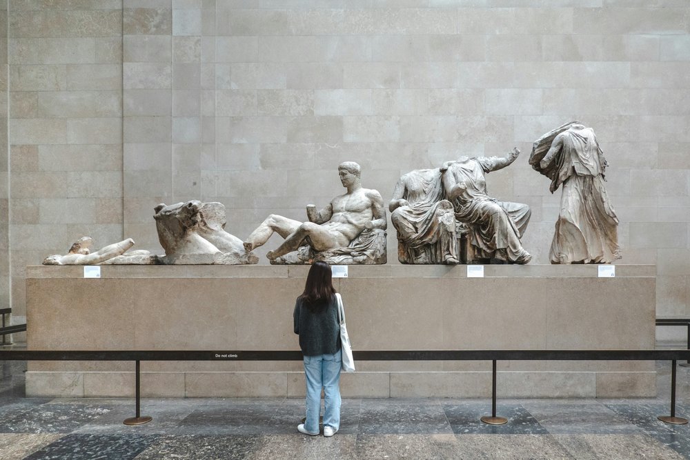  Visitor viewing ancient Greek marble sculptures inside the British Museum | Photo Credit: Taylor Keeran on Unsplash