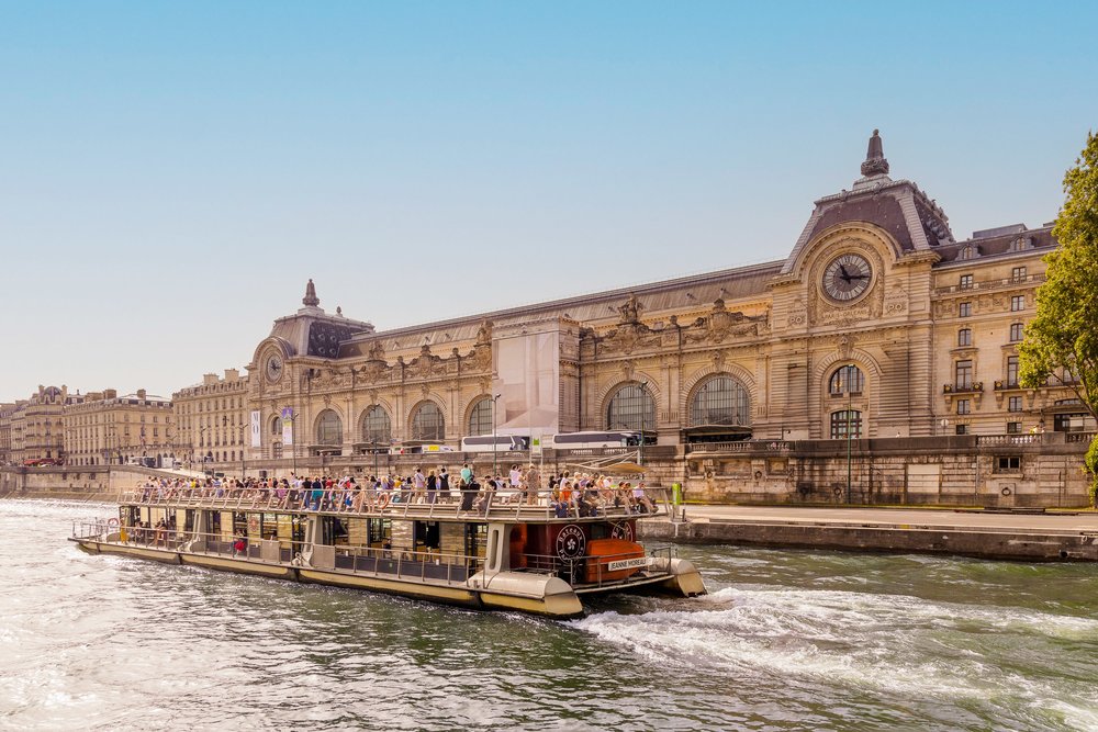 Sightseeing boat cruising the Seine River near historic buildings in Paris