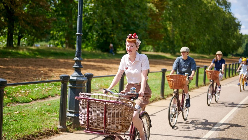  People cycling along a park path in London on a guided bike tour