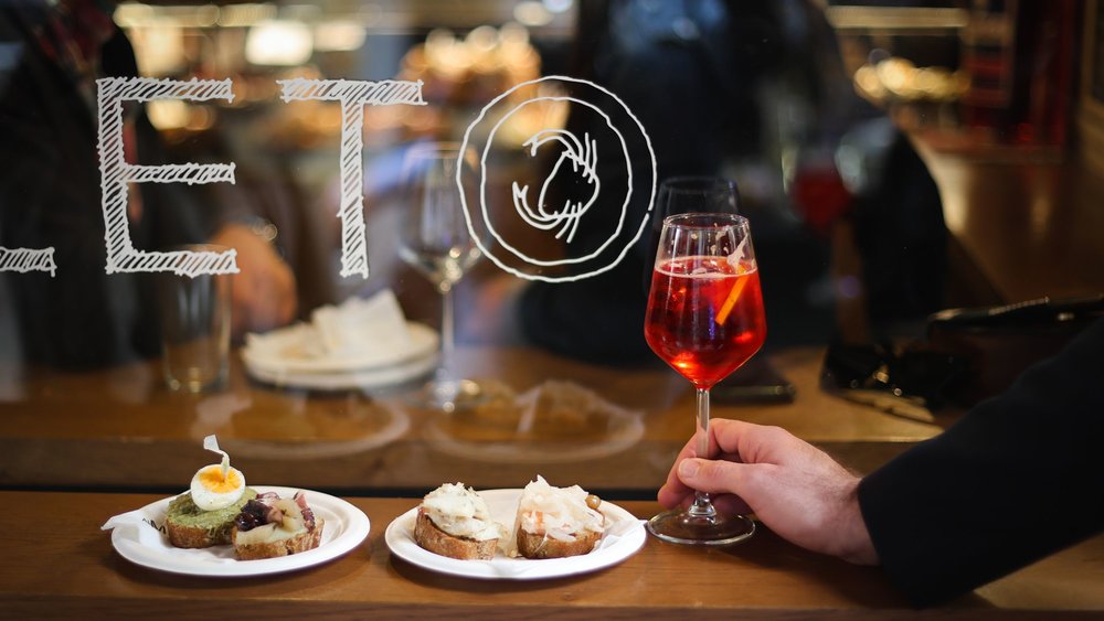 Venetian cicchetti snacks on bread with a glass of spritz at a local bacaro