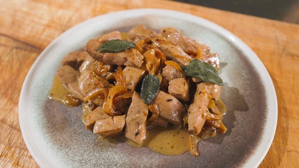 Venetian-style calf liver cooked with onions served on a ceramic plate
