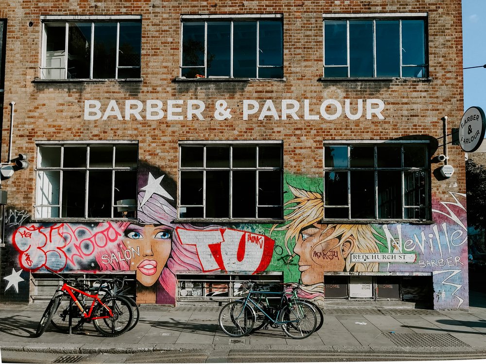 Street art–covered building with parked bicycles in a London neighborhood | Photo Credit: Tiff Ng on Pexels