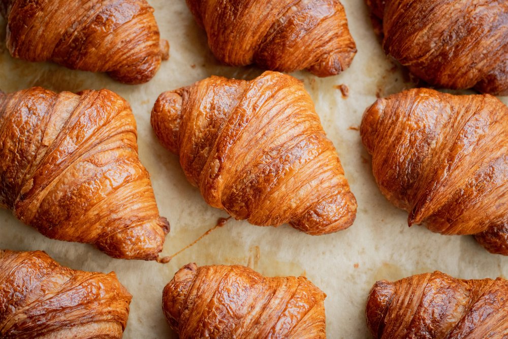 Rows of freshly-baked croissants at a boulangerie.