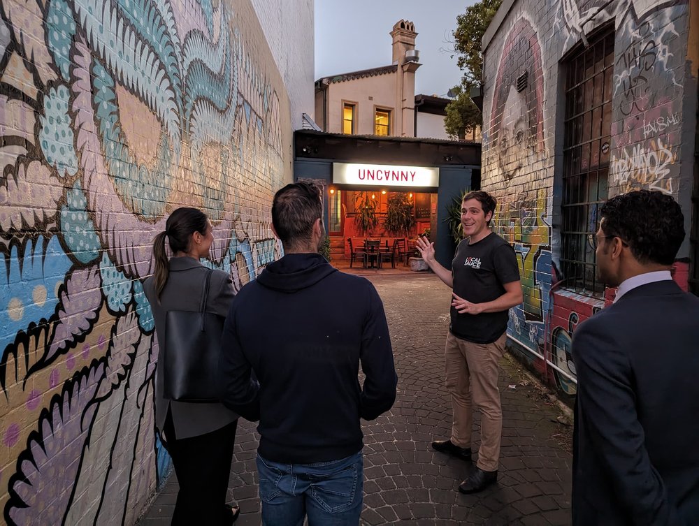 Sydney art galleries - Group joining a guided street art tour in a mural-filled Sydney laneway