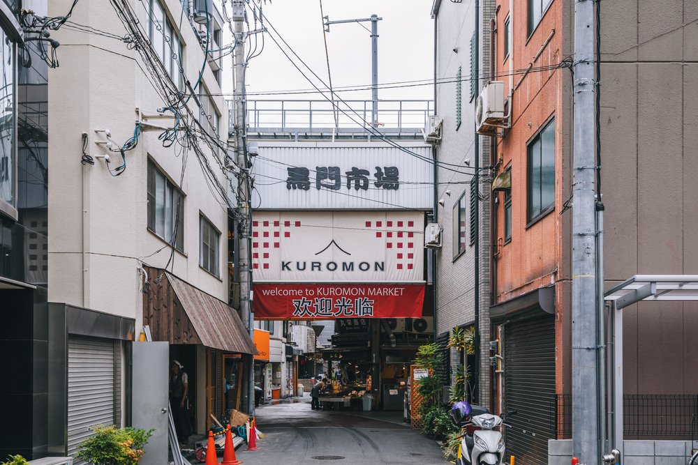 Kuromon Market entrance with shops selling fresh food in Osaka