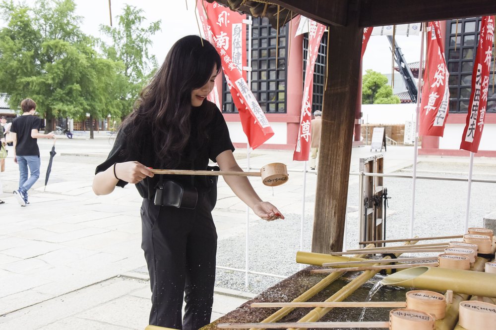 Tourist washing hands at Shitennoji Temple, one of Osaka’s oldest temples