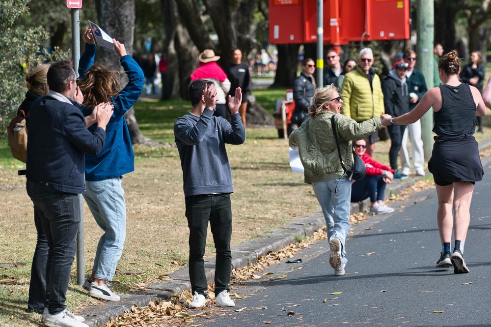 People cheering runners during a city marathon event in Sydney