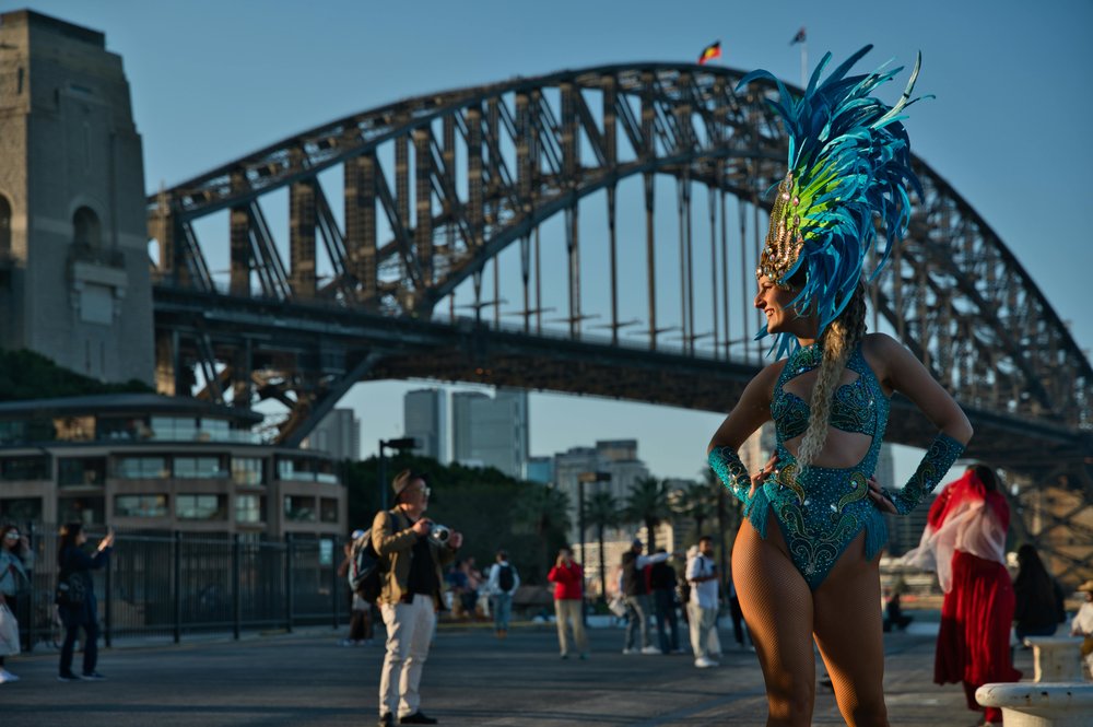 Festival performer posing near Sydney Harbour Bridge and waterfront