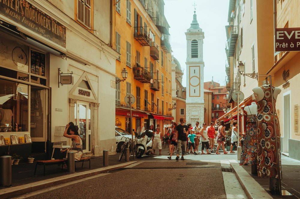 Lively street scene in Old Town Nice with shops and pastel buildings