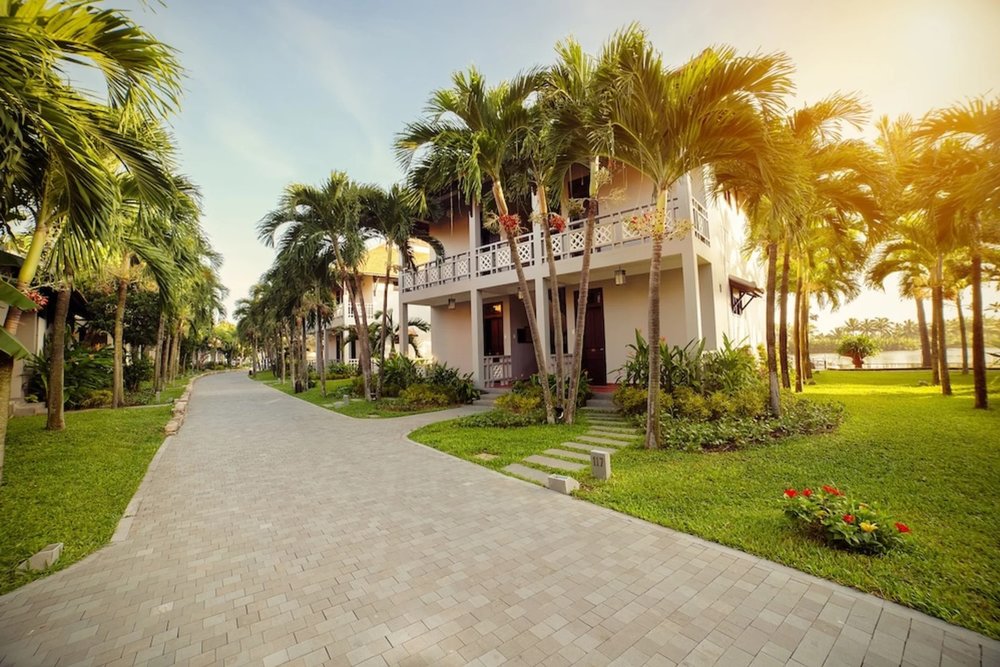 Hoi An Beach Resort villas surrounded by palm trees and garden paths