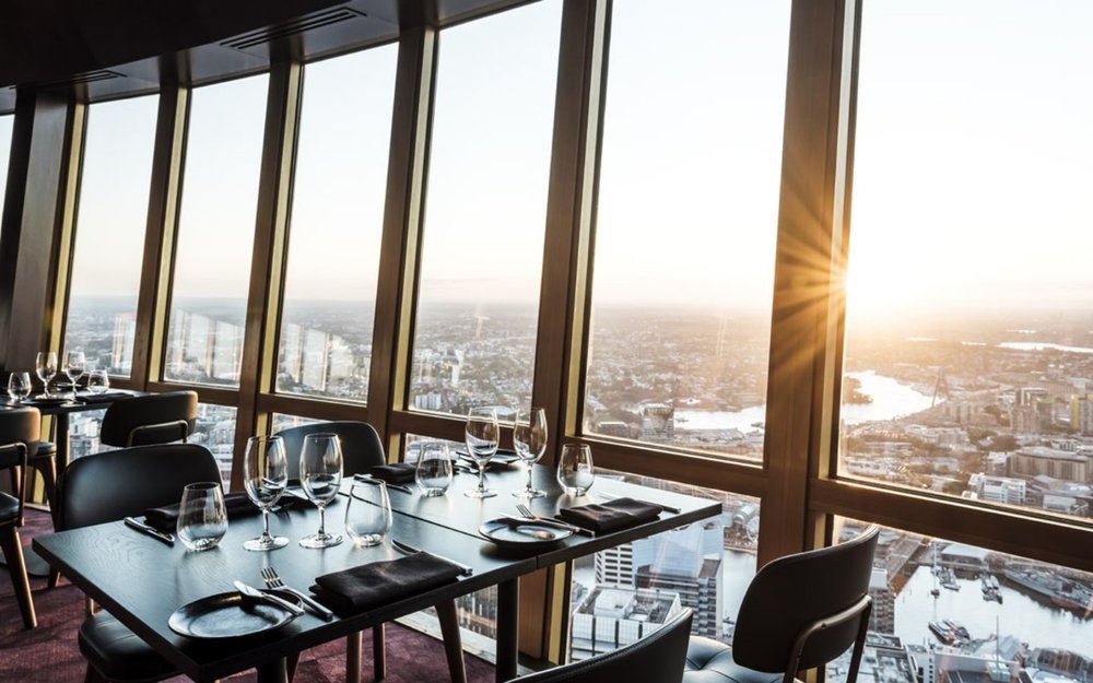 Elegant restaurant with panoramic Sydney skyline views at sunset