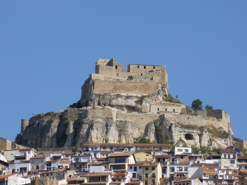 Ancient stone castle overlooking a traditional white village in Spain