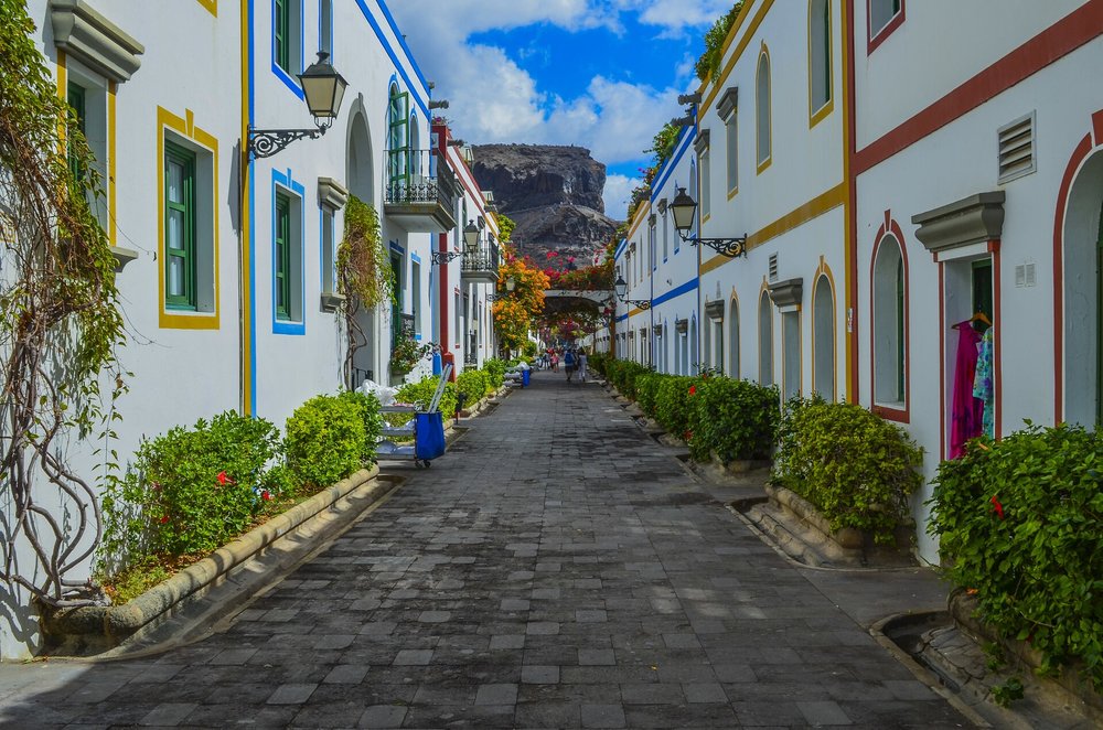 Charming village street in Spain lined with colorful houses and greenery