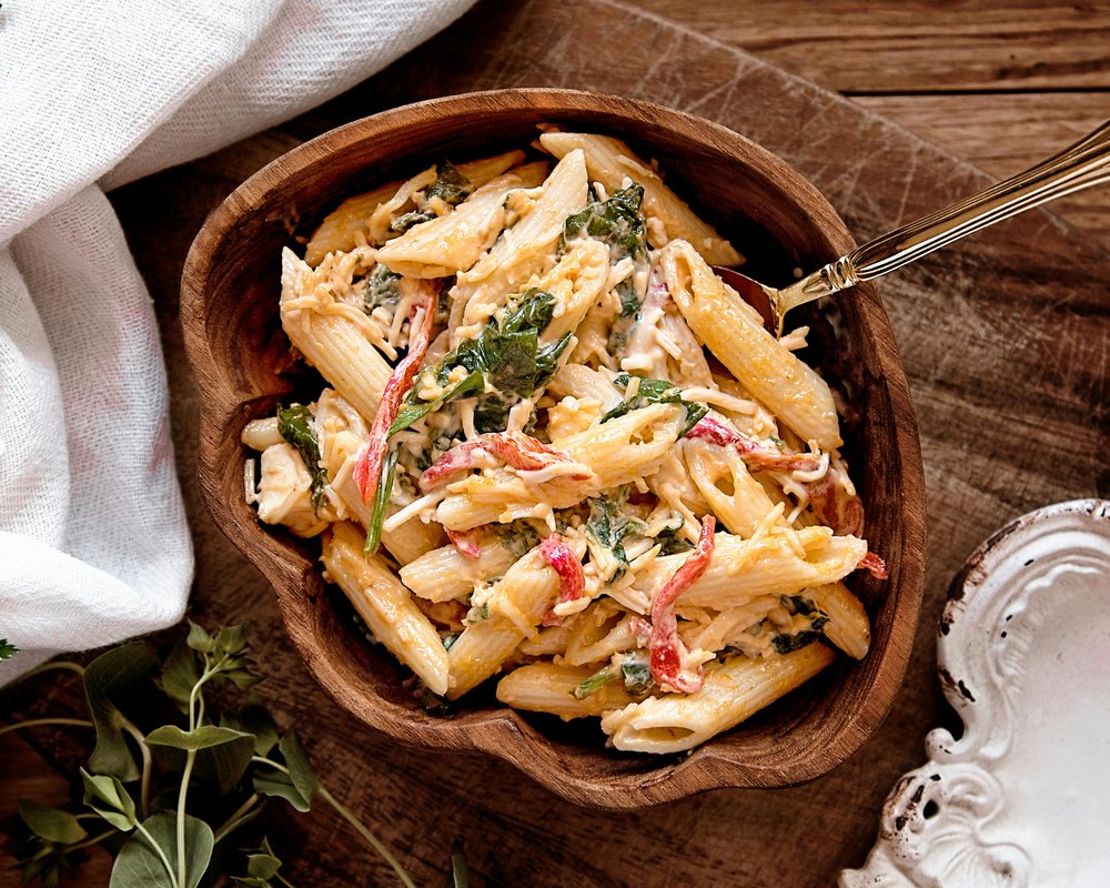 Close-up of creamy penne pasta with cheese and fresh herbs