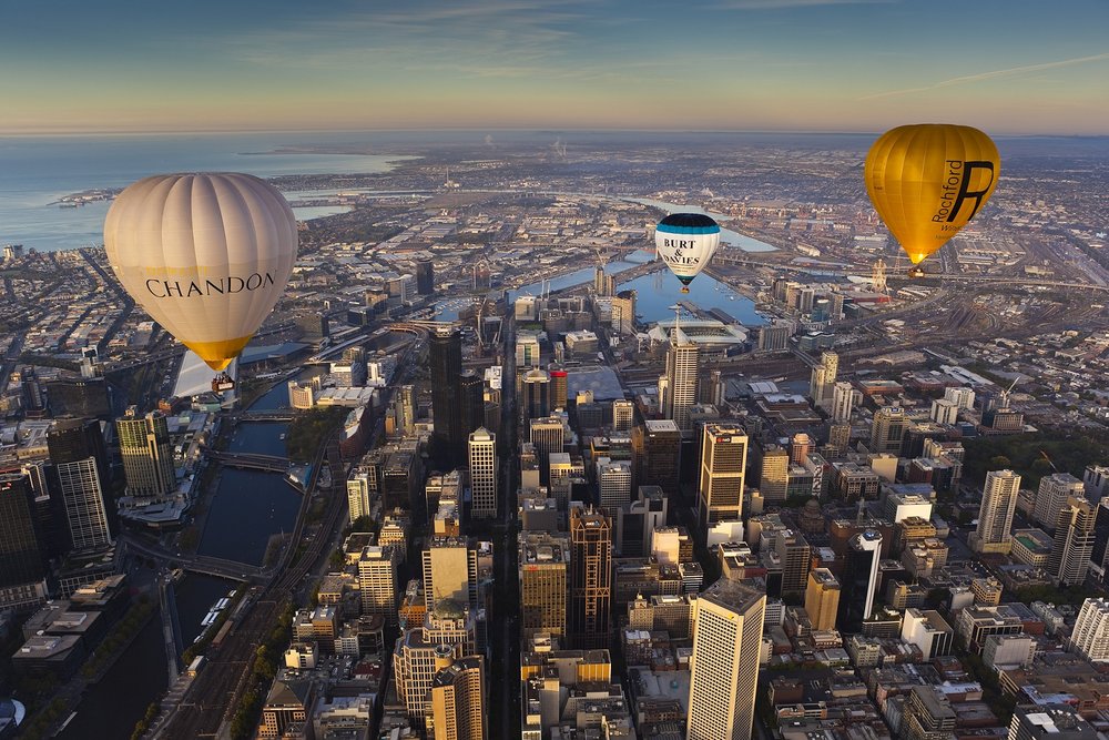 Hot air balloon flight over Melbourne city skyline during sunrise