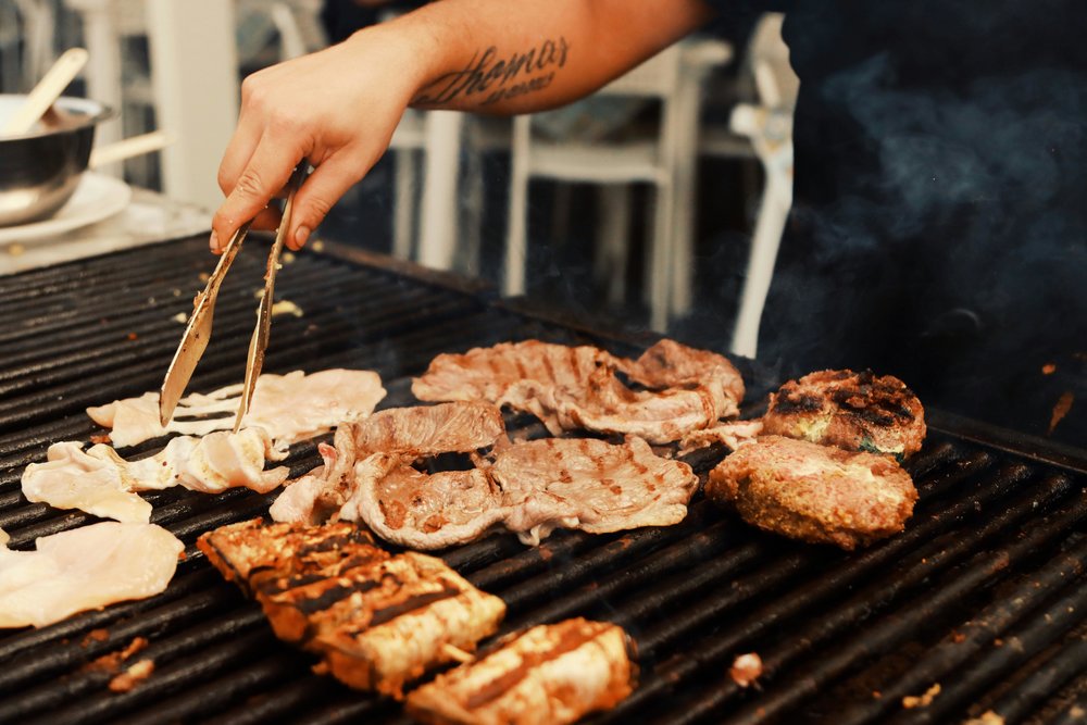 Traditional Italian grilled meats sizzling on a barbecue grill
