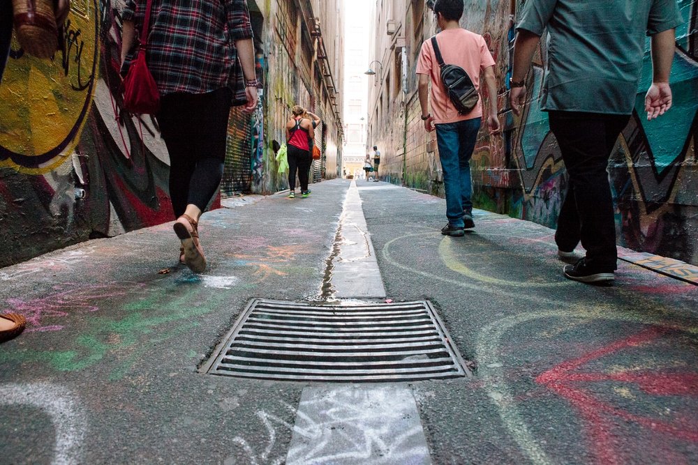 People walking through colorful street art laneways in Melbourne CBD