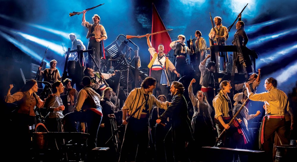 Cast performing a dramatic scene from the Les Misérables musical in London’s West End