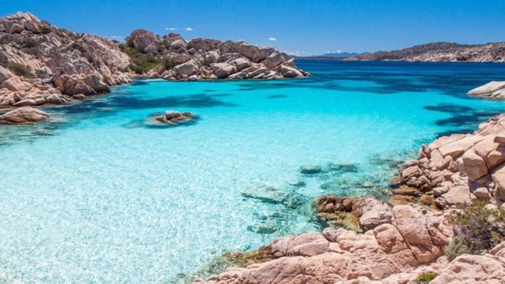 A clear, blue body of water in between two rock formations