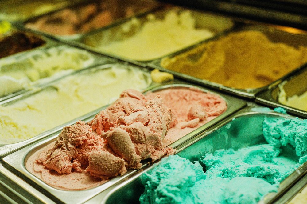 Traditional gelato trays filled with pistachio, fruit, and cream flavors in Rome