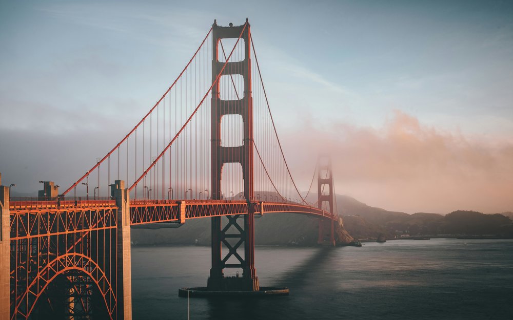 Golden Gate Bridge in San Francisco stretching over water with light fog