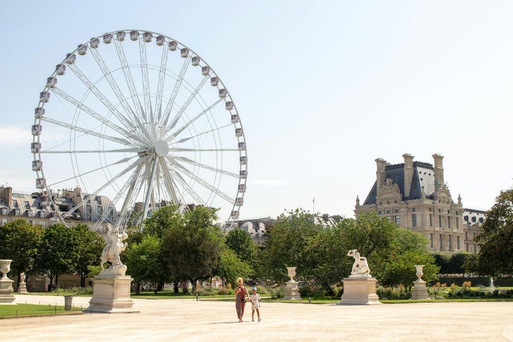  Tuileries Garden with Ferris wheel and historic buildings in Paris | Photo Credit: Kirsten Drew on Unsplash