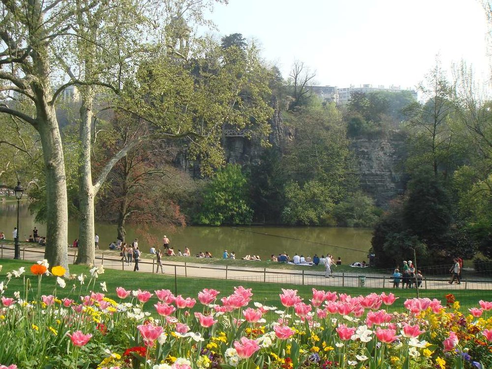  People relaxing by the lake and flowers at Parc des Buttes-Chaumont in Paris | Photo Credit: PICRYL