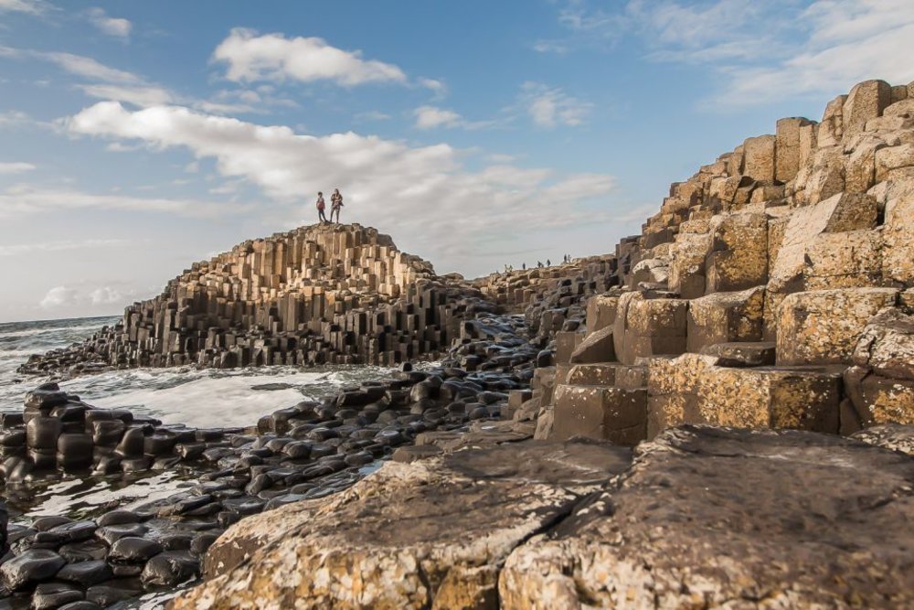 Visitors standing on the basalt columns of the Giant’s Causeway in Northern Ireland