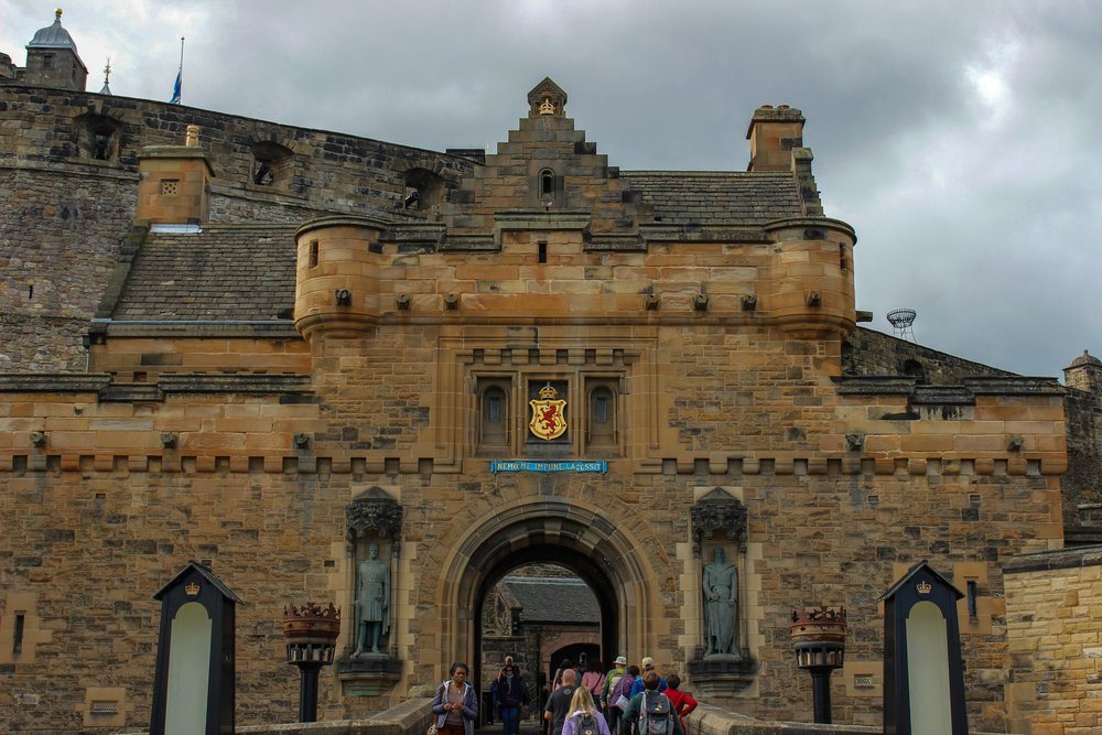 Visitors entering Edinburgh Castle through the historic stone gate