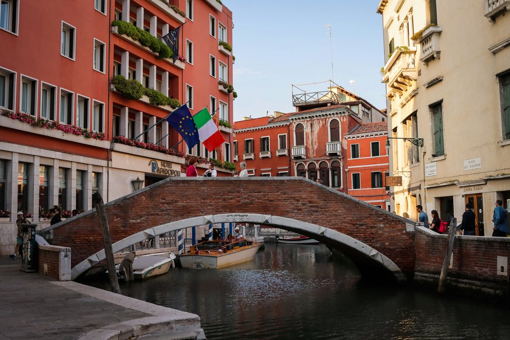 Small canal and brick bridge in Venice during a calm afternoon