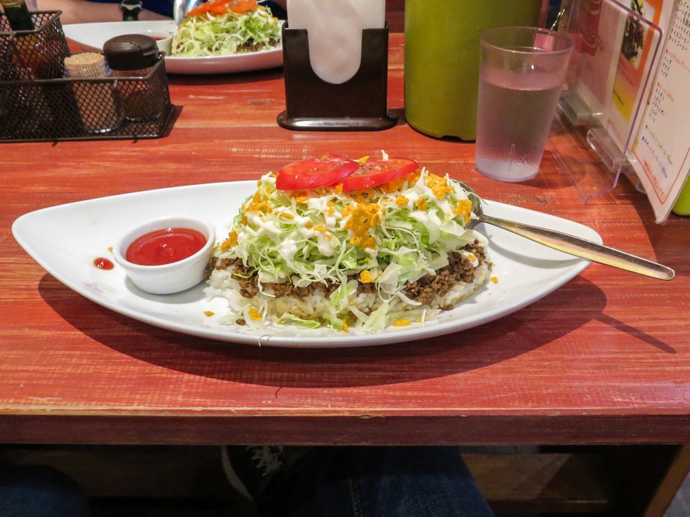 Taco rice in Okinawa with ground beef, shredded lettuce, cheese, and salsa