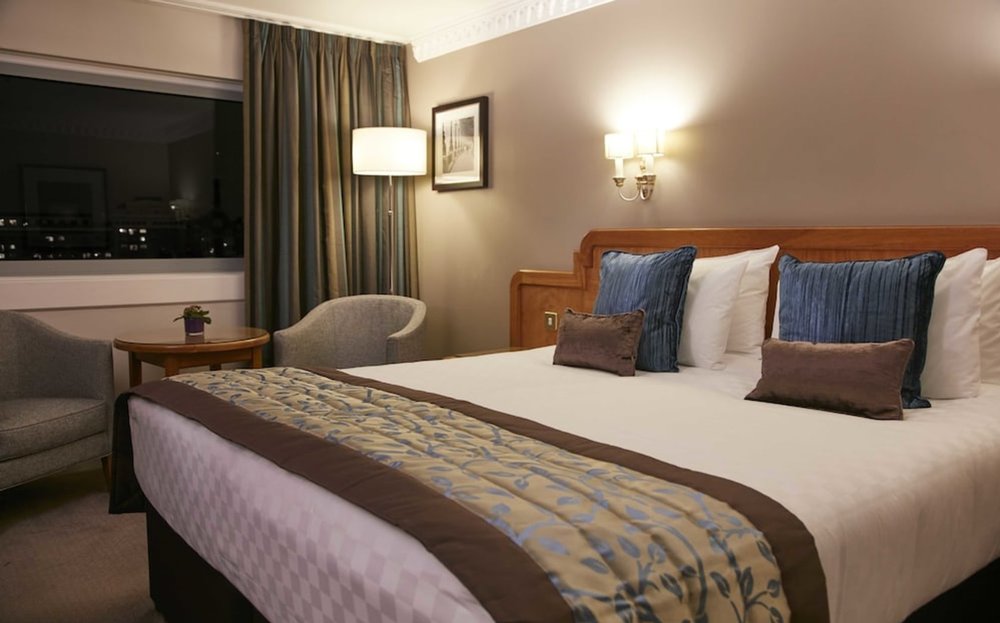 Modern hotel bedroom in central London with double bed and seating area