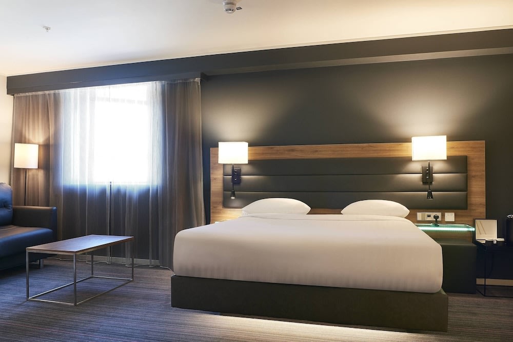 Modern London hotel room with king-size bed, desk, and soft lighting