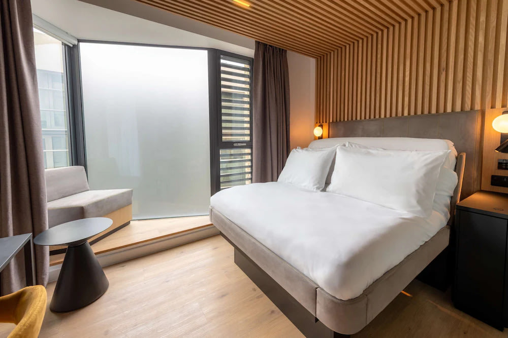 Contemporary London hotel room with large windows and modern furnishings