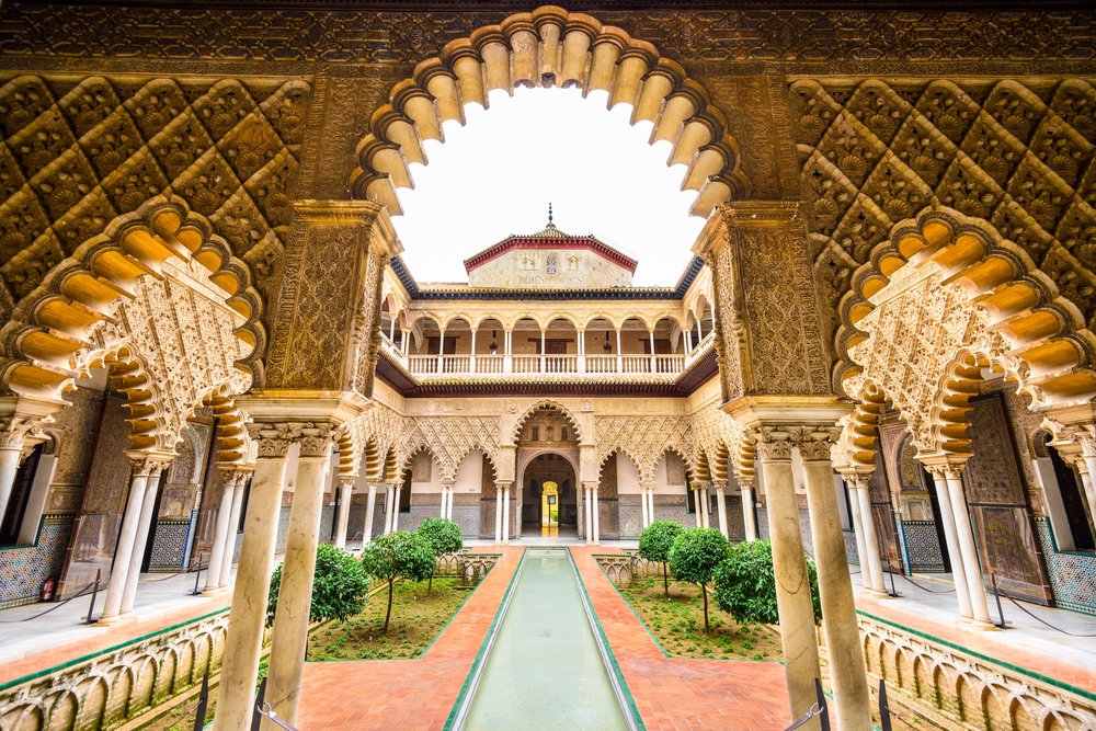 Arched courtyard with columns and reflecting pool at the Royal Alcázar of Seville 