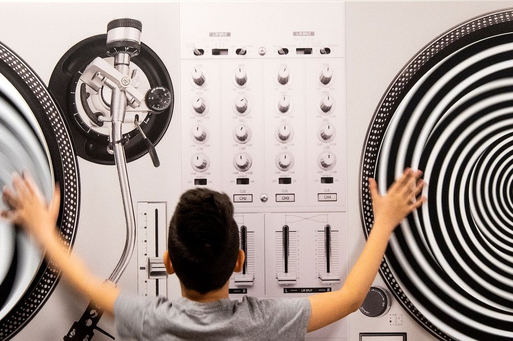 Visitor interacting with a giant optical illusion display at the Museum of Illusions
