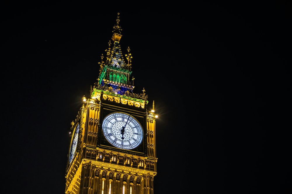 Big Ben glowing at night against a dark London sky