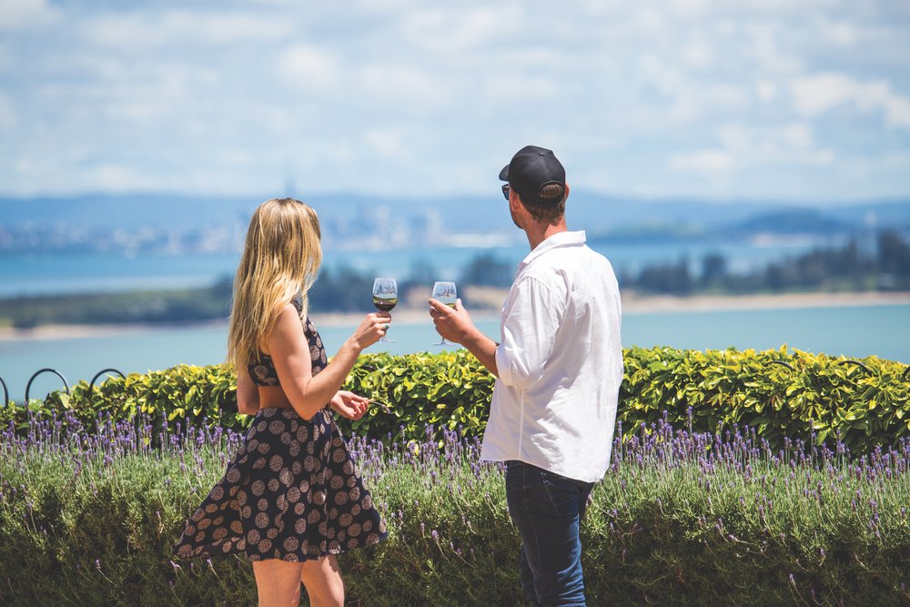 Couple tasting wine overlooking the ocean during a Waiheke wine tour