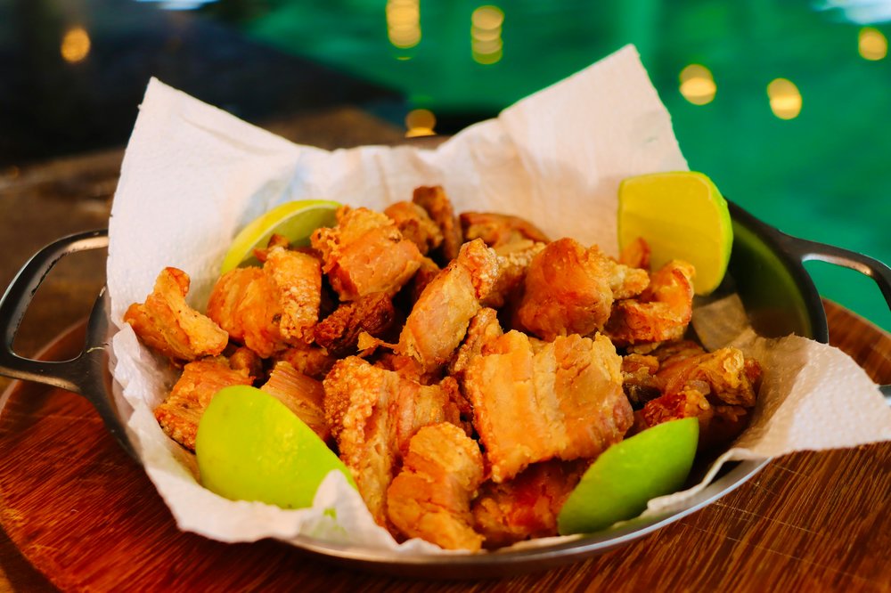 Crispy fried pork pieces with lime wedges at a cheap restaurant in Sydney
