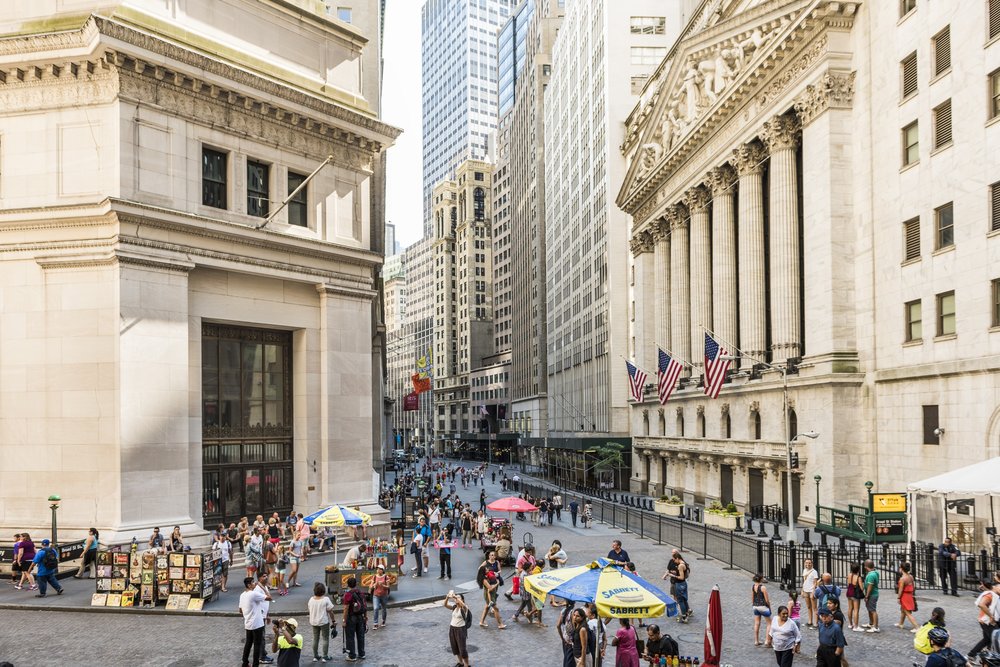 Wall Street financial district with classic architecture and pedestrians in NYC