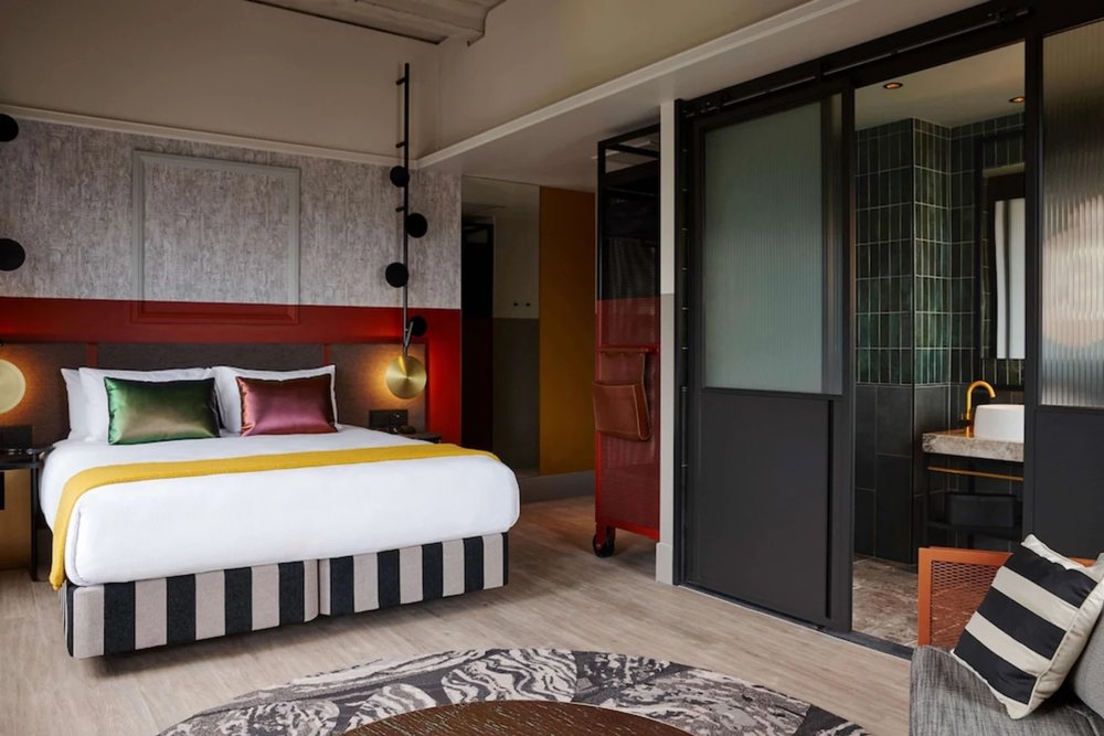 Modern hotel room at QT Auckland featuring colorful decor and contemporary design