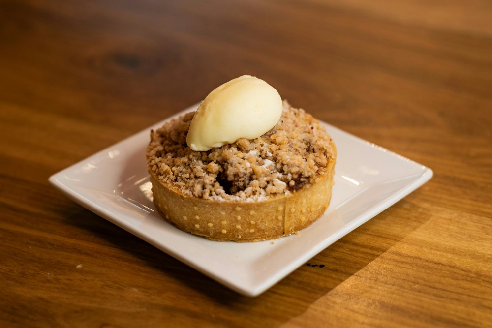 Apple crumble tart topped with vanilla ice cream