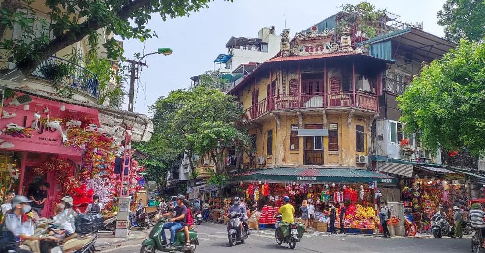 Hanoi Old Quarter’s vibrant market scene with motorbikes and shops