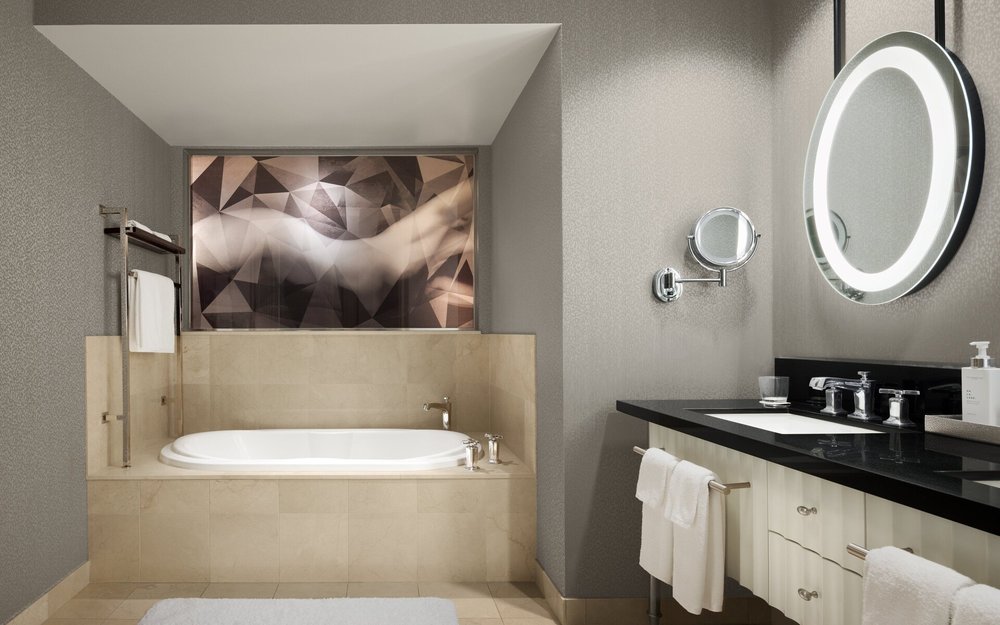 Luxury Cosmopolitan Las Vegas bathroom featuring deep soaking tub, illuminated mirror, and contemporary design