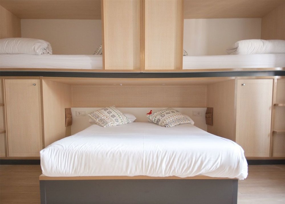 Clean private hostel room with double bed and bunk beds in Madrid