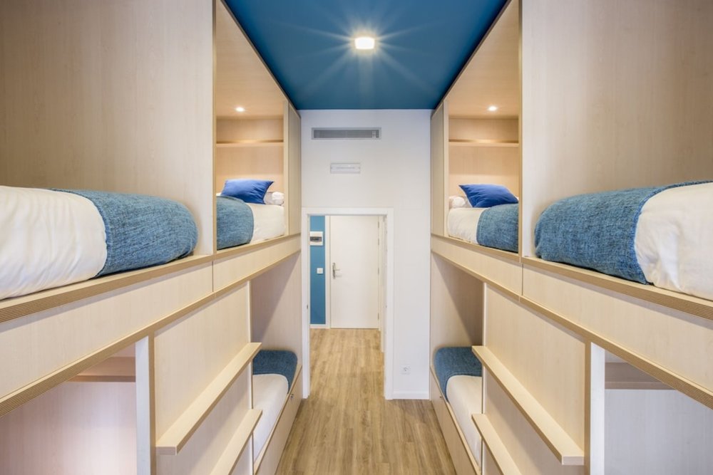 Modern capsule bunk beds inside a stylish youth hostel in Madrid
