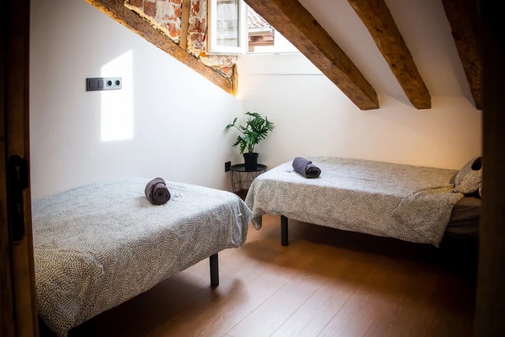 Cozy private twin room with wooden beams in a Madrid budget hostel