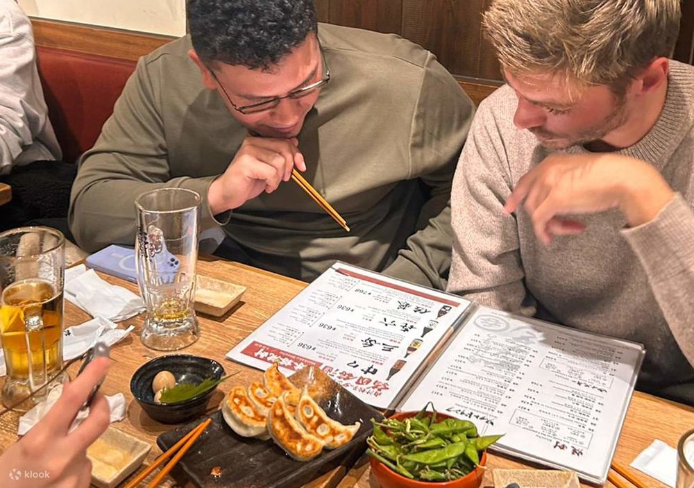 Two men looking through a beer menu